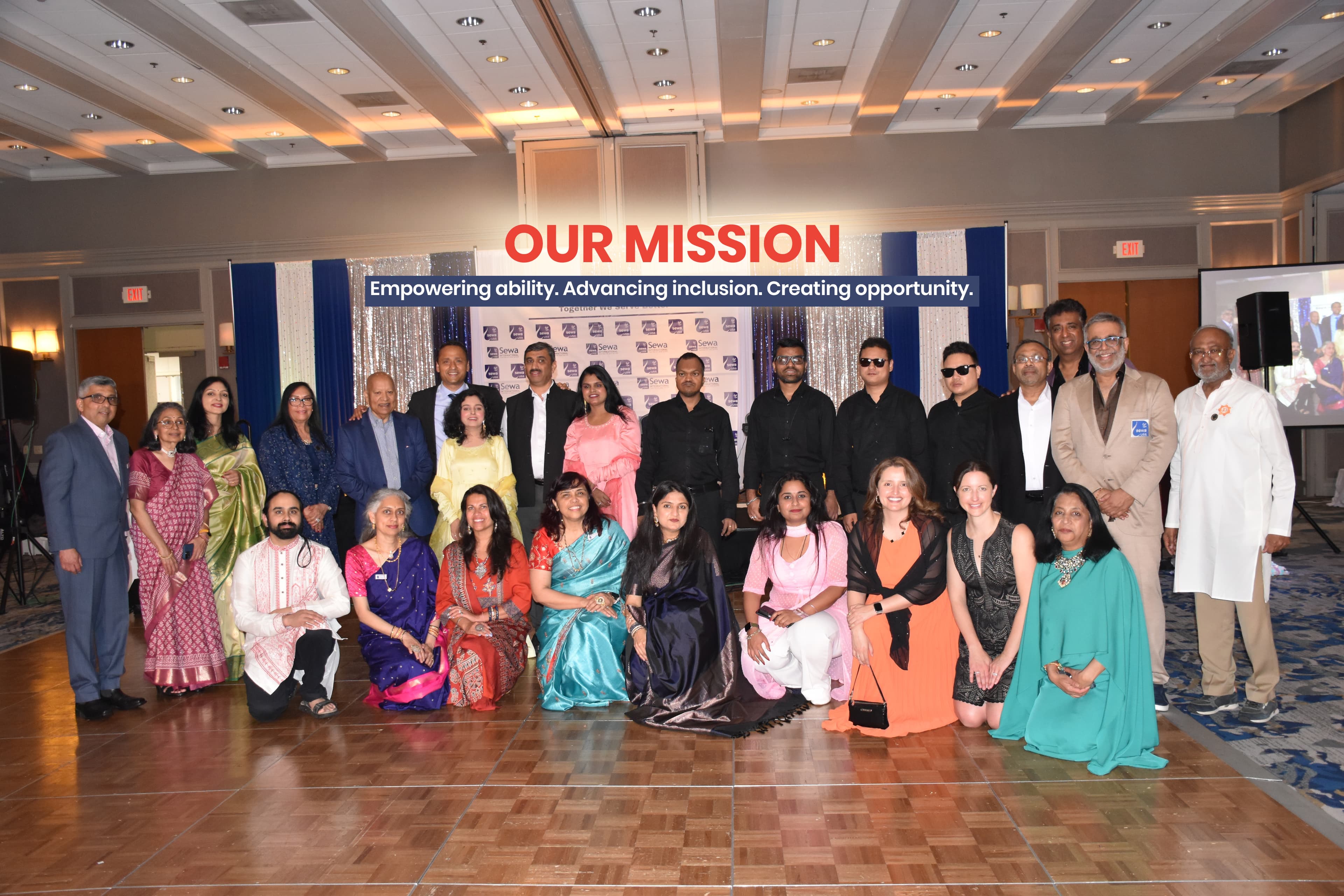 A group of people with disabilities smiling and looking at the camera.